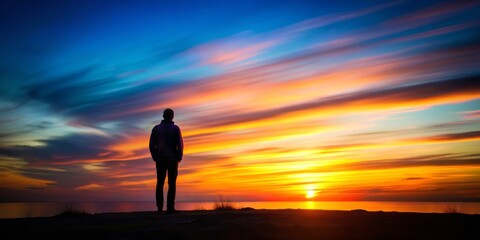 Fototapeta premium Silhouette portrait of a solitary figure against vibrant sunset hues, exuding melancholy, captured with slow shutter speed and intentional blur, conveying fleeting nature of life.