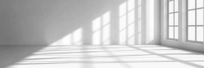 Fototapeta premium A clean, modern interior with a white wall, a window, and sunlight casting soft shadows across the floor. It symbolizes simplicity, tranquility, and the potential for new beginnings.
