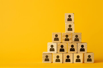 Business creation. Selection of the right people. Business hierarchy. Wooden cubes with icons of people on yellow background