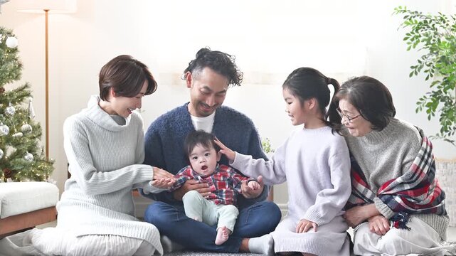 リビングでリラックスして過ごす冬の家族　3世代、同居、二世帯住宅のイメージのスロー動画　クリスマスツリーあり