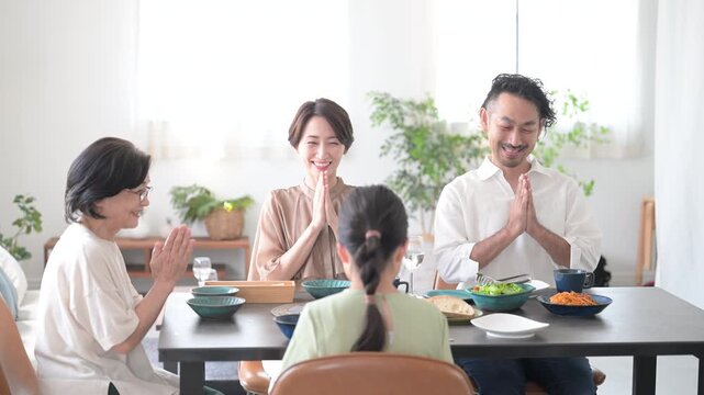 Slow motion picture of a family of three generations having an Itadakimasu dinner table scene