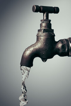 Old vintage faucet with flowing water