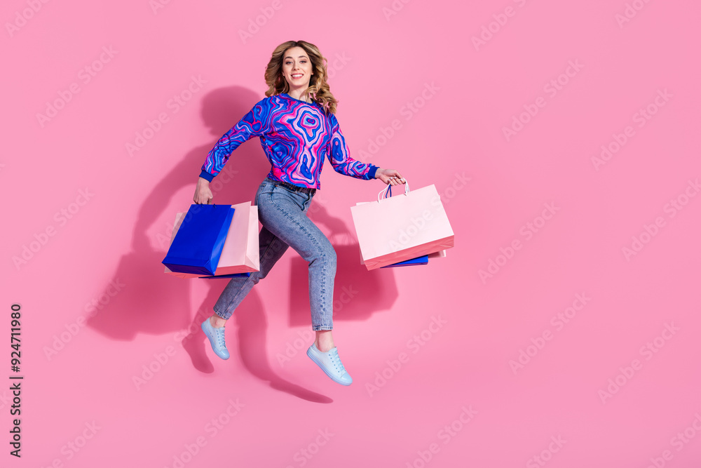 Poster Photo of happy girl shopaholic fashion addicted running holding packages gifts black friday promoter isolated on pink color background