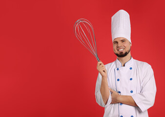 Naklejka premium Happy pastry chef with big whisk on red background. Space for text