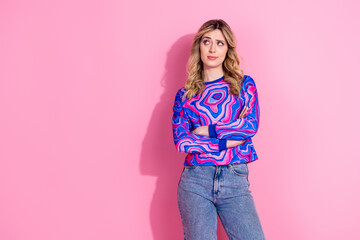 Photo of blonde young girl folded arms wearing trendy bright sweatshirt looking empty space brainstorming isolated on pink color background