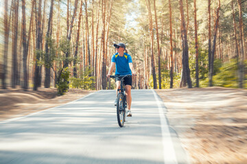 Fototapeta premium woman cyclist rides in the forest on a bike.
