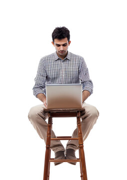 Young men IT, setting on chare working on laptop isolated