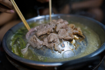 Group friends having party eating Thai style local hot pot in outdoors camping at night