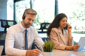 Portrait of call center worker accompanied by his team. Smiling customer support operator at work.