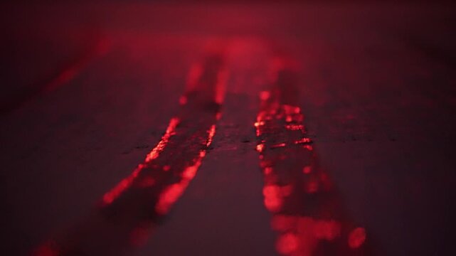 Rote lichtreflexion auf dem Boden bei Nacht von Ampel