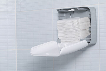 New fresh paper towels into the dispenser in the bathroom after finished installation. Close-up