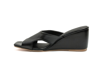 Modern fashionable women's black leather wedge sandals have a low, angled heel and an open-toe design isolated on a white background.