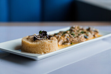 Couscous porridge with meat and mushroom sauce on a white plate