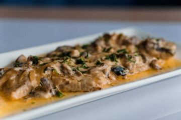 Couscous porridge with meat and mushroom sauce on a white plate