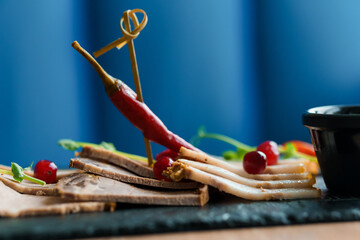 Sliced meat with sauce and breadsticks