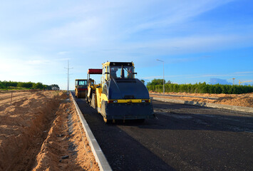 Asphalting paving repairing works. Vibrator compactor machine on roadworks on city street. Asphalt...