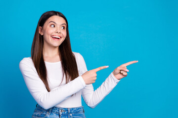 Photo portrait of lovely teen lady point look empty space dressed stylish white garment isolated on blue color background