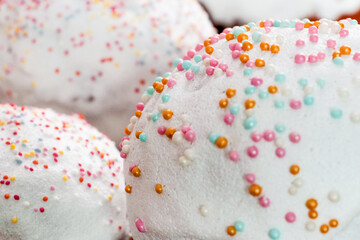 Flour pastries with white icing and colorful balls