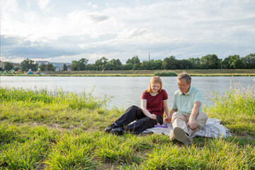 Fototapeta premium father and daughter sitting on the grass and eating ice cream