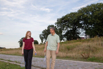 father and daughter playing badminton outdoor