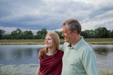 Obraz premium father and teenage daughter relaxing together outdoors in summer