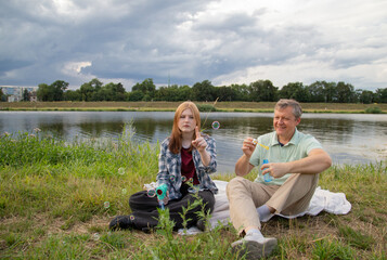 Fototapeta premium father and teenage daughter relaxing together outdoors in summer