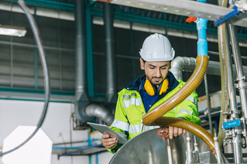 Industrial factory worker, Engineer staff working in food and drinks factory, Control check quality condition of liquid pipe supply in plant.