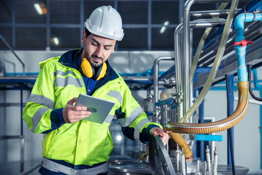 Industrial factory worker, Engineer staff working in food and drinks factory, Control check quality condition of liquid pipe supply in plant.