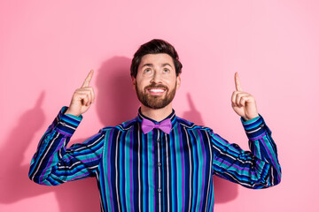 Portrait of nice classy young man direct fingers up empty space wear shirt isolated on pink color background
