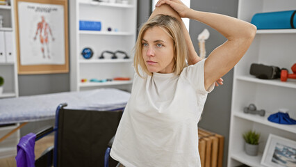 A young attractive caucasian woman poses indoors in a physiotherapy rehabilitation clinic.