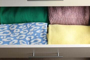 Chest of drawers with different folded clothes, above view