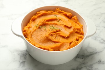 Delicious mashed sweet potatoes in pot on white marble table, closeup