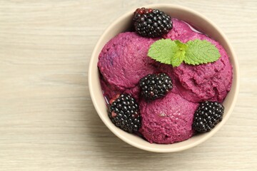 Delicious blackberry sorbet, fresh berries and mint in bowl on wooden table, top view