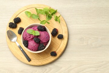 Delicious blackberry sorbet with fresh berries in bowl and spoon on table, top view. Space for text