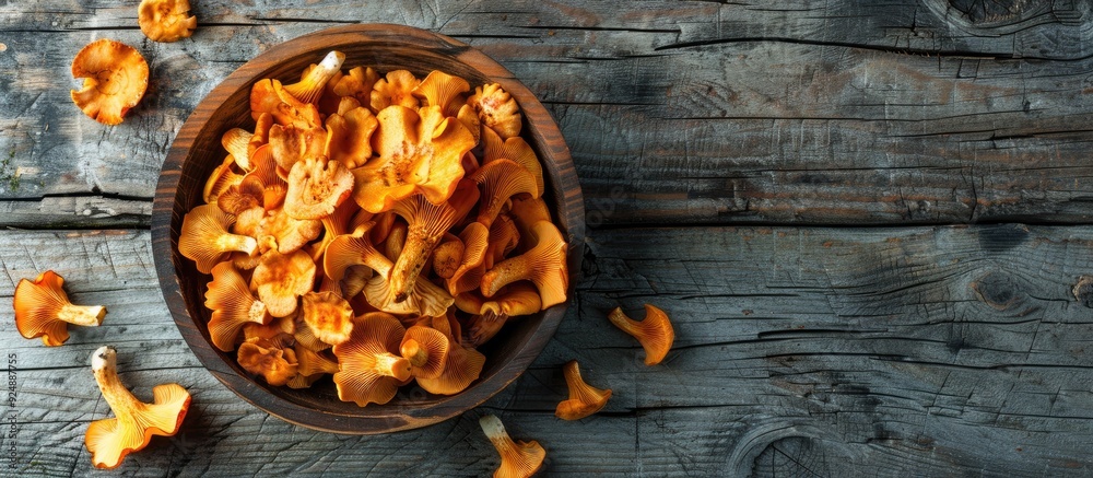 Poster Fresh chanterelle mushrooms make a delicious snack on the rustic table with a copy space image background in a top view