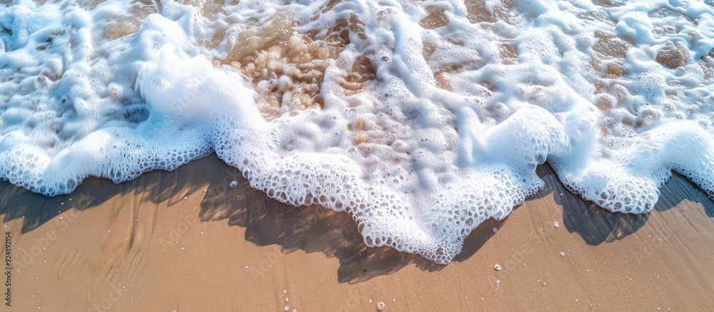 Poster sandy beach in summertime with gentle waves and white foam ideal as copy space image for travel them