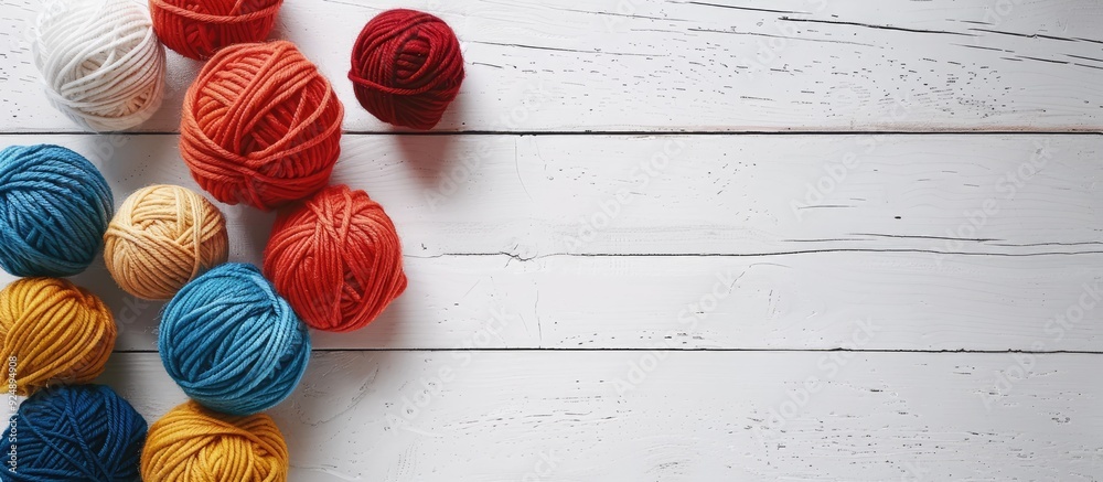 Poster Woolen yarn balls arranged neatly on a clean white wooden tabletop providing ample copy space image