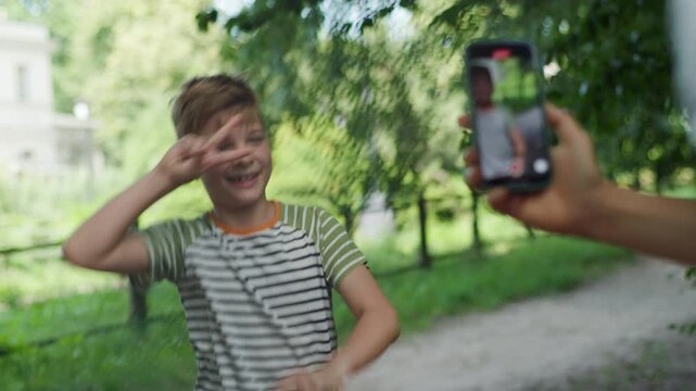 Capturing a joyful moment, a mom records her child dancing on her cellphone, illustrating the sharenting trend of sharing kids' lives online