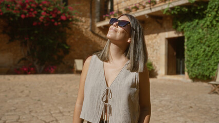 Young woman enjoying sunny day outdoors in beautiful mallorca, spain, surrounded by mediterranean architecture and vibrant flowers