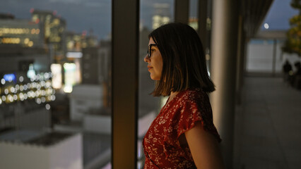 Beautiful hispanic businesswoman in glasses, captivating cityscape view from skyscraper window in japan's urban skyline