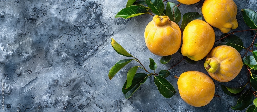 Poster Fresh organic quinces with leaves on a grey table top view perfect for adding text in the copy space image