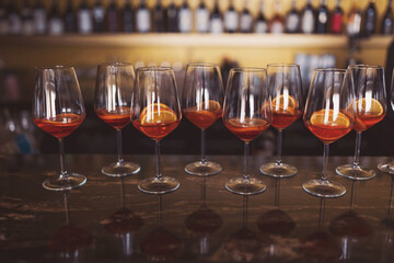 process of preparation of a cocktail Aperol spritz. Glasses of alcoholic Aperol Spritz cocktail. Italian aperitif with ice, aperol, prosecco, soda and slice of orange in large round glasses on party.