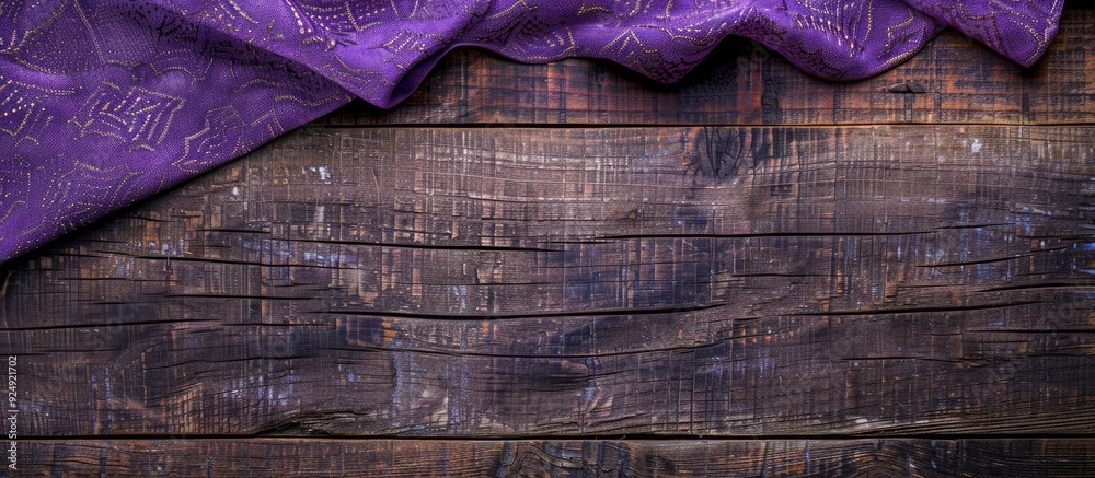 Aufkleber top view of a purple patterned tablecloth on a wooden surface background with space for text or imag