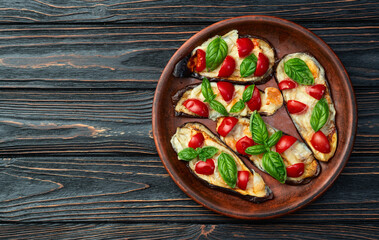 Italian mini pizza . Aubergine (eggplant ) with mozzarella cheese and basil . On rustic background