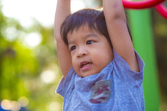 Little preschool boy enjoying climb outdoor city playground