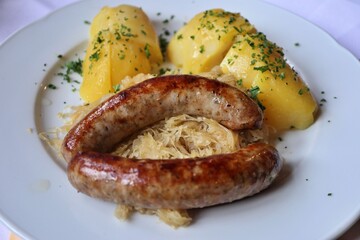 German cuisine: bratwurst (grilled pork sausages), potatoes and sauerkraut (sour cabbage) in Rothenburg ob der Tauber, Germany