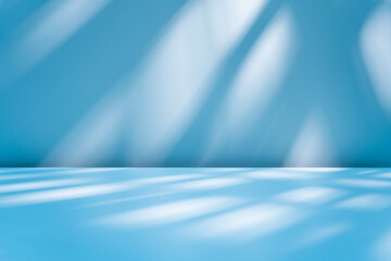 Abstract blue background for product presentation with sunlight and blurred shadows wall. Winter background.
