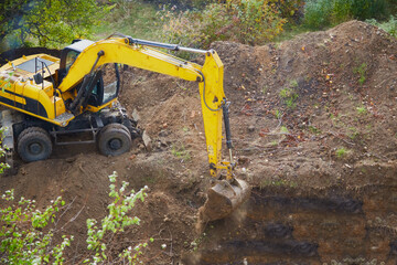 Excavator digging an excavation with a bucket, excavator bucket operating on a construction site