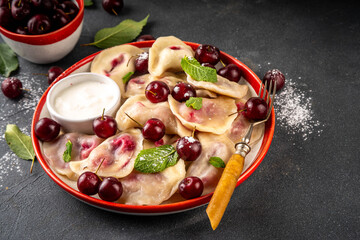 Traditional West Europe Dumplings with Cherries, ukrainian, polish vegan Cherry Pierogi, Sweet berry fruit Vareniki, ravioli with sour cream and sugar powder