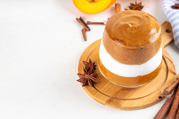 Pumpkin Spice Dalgona Coffee cocktail, sweet tasty autumn latte with pumokin puree, whipped cream and whipped instant dalgona coffee foam